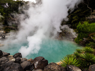 Beppu's Chinoike Jigoku, known as the "Blood Pond Hell." The steamy, red-hued hot spring emits mist from its vibrant, mineral-rich waters, creating an otherworldly, surreal atmosphere. Beppu jigoku.