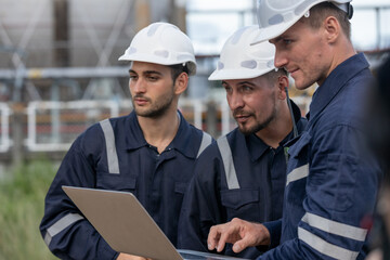 Team engineer working using laptop together at tank station refining oil petrochemical factory....