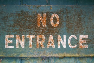 Fototapeta premium Old inscription NO ENTRANCE on a dark background.