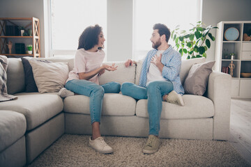 Photo of positive girl guy sit divan couch communicate in flat apartment indoors