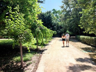 Fototapeta premium Photo of people strolling through the National Garden of Athens on a beautiful hot summer day. The park provides a calm and beautiful haven in the middle of Athens.