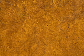 A close up of an aged textured ochre wall