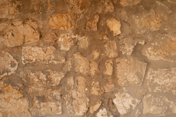 A rustic stone wall with unevenly sized stones The natural textures of the stones create a captivating backdrop