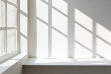 Fototapeta premium Soft shadows fall across a plain white wall from a minimalist window frame, creating a calm atmosphere in a well-lit indoor space