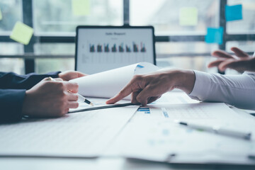 Asian men and women business team meeting financial graph document Calculators and laptops