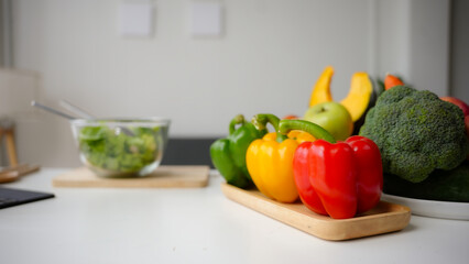 Variety of fresh produce sits on a white kitchen counter, showcasing healthy eating and meal preparation