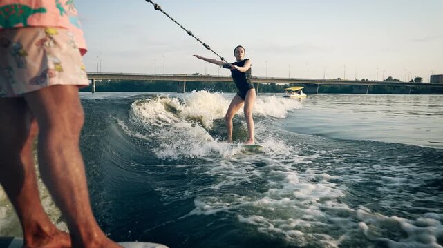 A girl on a wakeboard floats down the river.