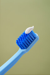 Mint background. Blue toothbrush with toothpaste on a green background, close-up.
