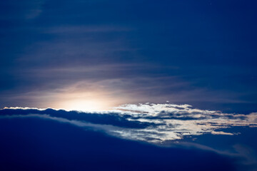 At night, the moon rises slowly over Turtle Island, where it is suddenly obscured by clouds and then exposed to the calm waters of the Pacific Ocean. Yilan County, Taiwan.