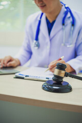 The hammer of justice is a law protecting doctors in diagnosing patients and leading to their death. Hospital insurance considers safety in judgment with lawyers, judges, courts, copy space.