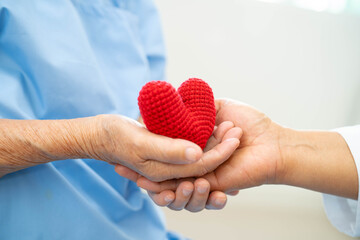 Asian doctor give red heart to elderly woman in her hand, heart Attack.
