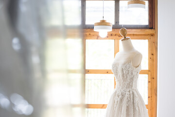 White wedding dress on a mannequin doll in studio.A wedding dress or bridal gown is the dress worn by the bride during a wedding ceremony.