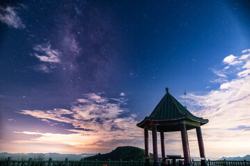 A traditional Chinese pavilion, Buyan Pavilion, stands against the night sky. Ethereal clouds...