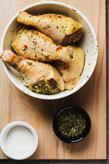 Raw chicken drumsticks with salt and spices.