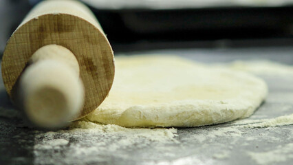 Close-up of the dough being flattened. Process of yeast dough preparation