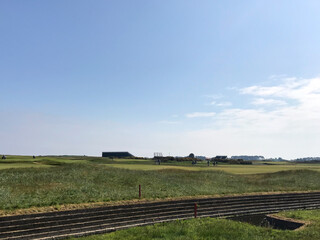 A large golf course from the side against a blue sky