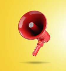 Red megaphone in air on yellow background