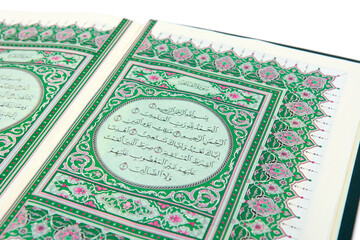 The Muslim holy book al quran surat al fatihah isolated on a white background with plants.