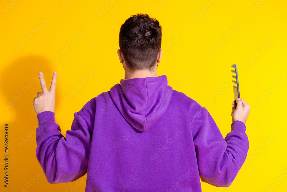 Poster Photo of groomed young nice man wear purple stylish clothes v-sign comb isolated on yellow color background