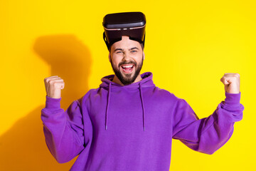 Photo of cheerful glad nice man wear purple stylish clothes vr glasses win game isolated on yellow color background