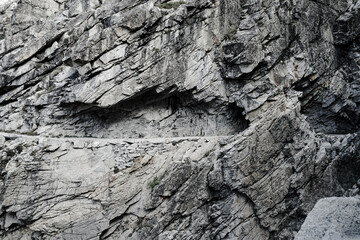 A rocky cliff with a small opening in it