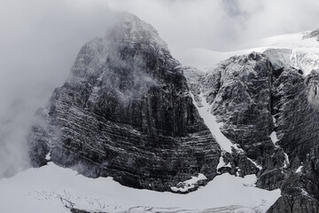 Obraz premium A mountain with snow on it and a foggy sky
