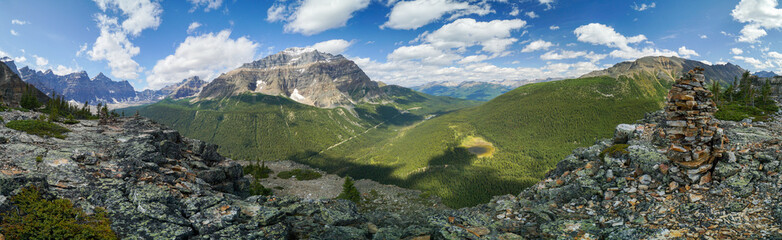 A panoramic view of a mountain range with a large rock on top