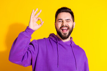 Naklejka premium Photo of positive cool nice man wear purple trendy clothes showing okey symbol isolated on yellow color background