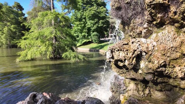 A small waterfall is flowing into a pond. El Retiro Park, Madrid