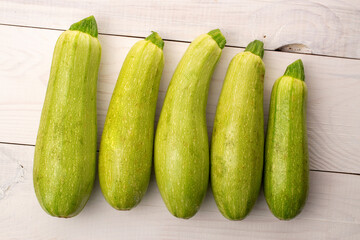 Several ripe zucchini on a wooden table, macro, top view.