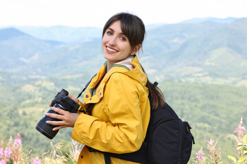 Photographer with backpack and camera in beautiful mountains