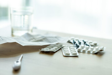 beautiful image of pills, medical prescription and medical thermometer on the table against the background of the window. Ideal for topics related to medicine, home treatment, disease epidemics