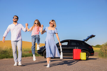 Obraz premium Parents, their daughter, car and suitcases outdoors. Family traveling