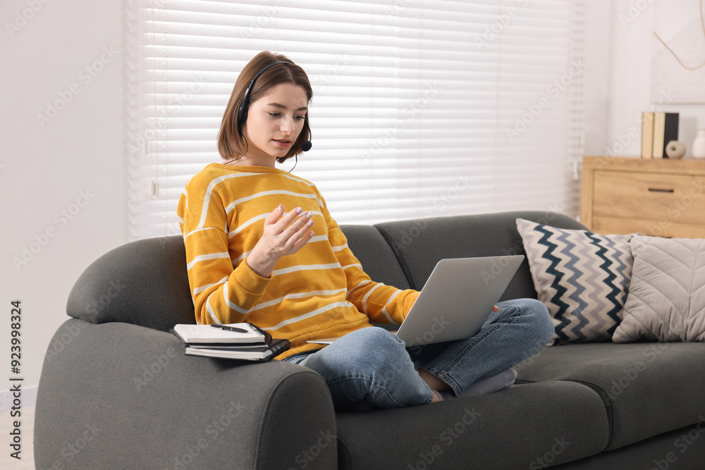 Canvas Prints Teenager in headset having video chat via laptop at home. Remote work