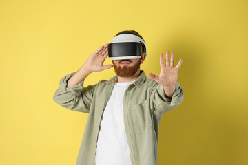 Man using virtual reality headset on pale yellow background