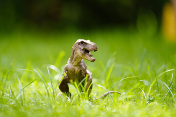 Child playing with dinosaur toy in sunny garden