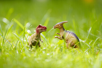 Child playing with dinosaur toy in sunny garden