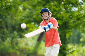 Kids playing cricket in summer park