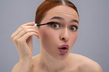 Luxury beauty model applying cosmetic mascara