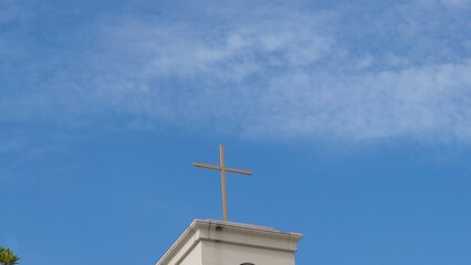 青空に薄らとかかる薄雲と十字架