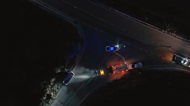 night Fatal road accident. police flashing lights. Roadside assistance loads wrecked car, police officer direct traffic