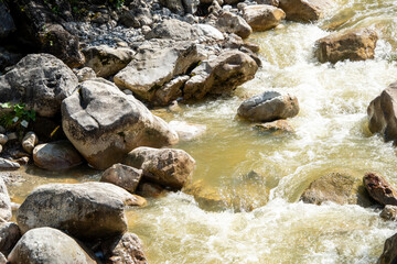 water flowing through pebbles in stream