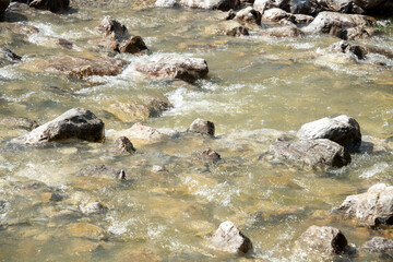 water flowing through pebbles in stream