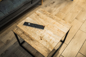 Tv remote concrol on a table in a living room closeup.Streaming service,cable tv concept.