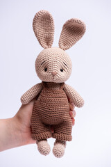 Handmade knitted amigurumi bunny toy on a white background.