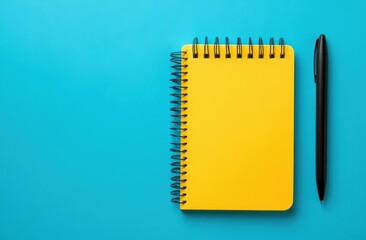 Yellow notebook with pen on blue background
