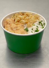 Bucket with chicken cream, white rice and screw noodles.