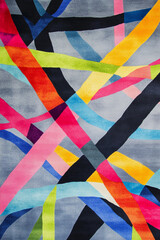 contemporary carpet design with an abstract pattern of bold, intersecting lines and vibrant colors like electric blue, neon green, and hot pink. The background is a muted gray to enhance the contrast,