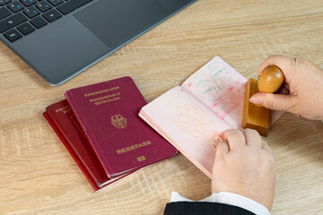 Close-up of female border patrol officers meticulously inspecting foreign passports, visa permits...