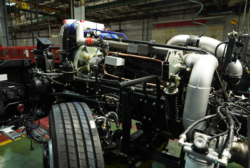 Truck production line. Assembly line. Engine install on frame of Wheel chassis of Heavy duty truck plant. Workshop production of Heavy duty trucks. Trucks Manufacture. Assembly line of truck factory.